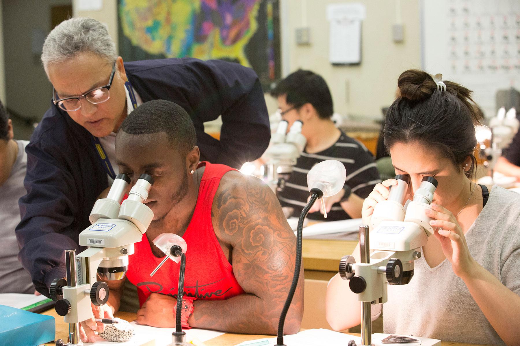 Stem professor assists student in the classroom.