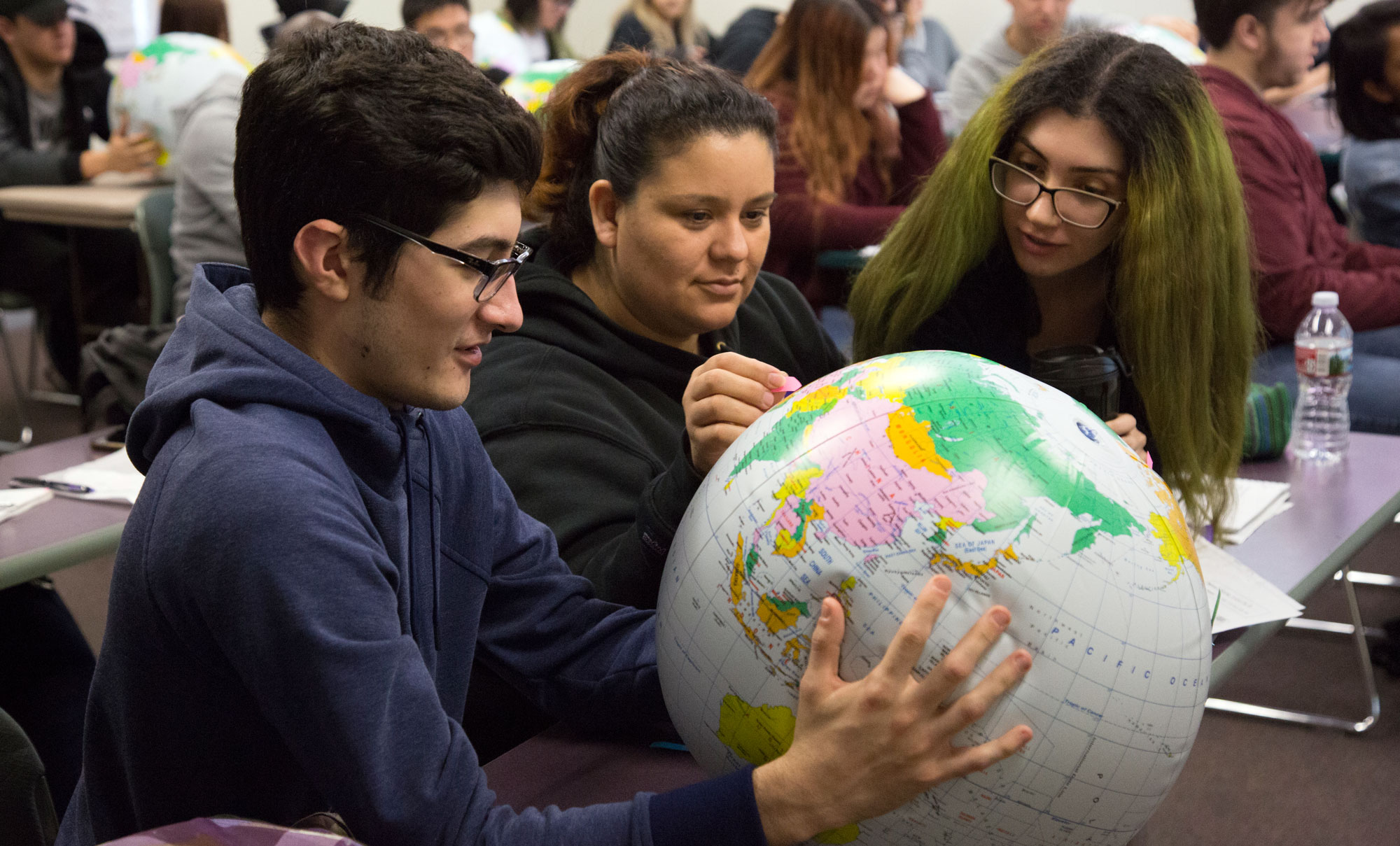Students study a globe during class