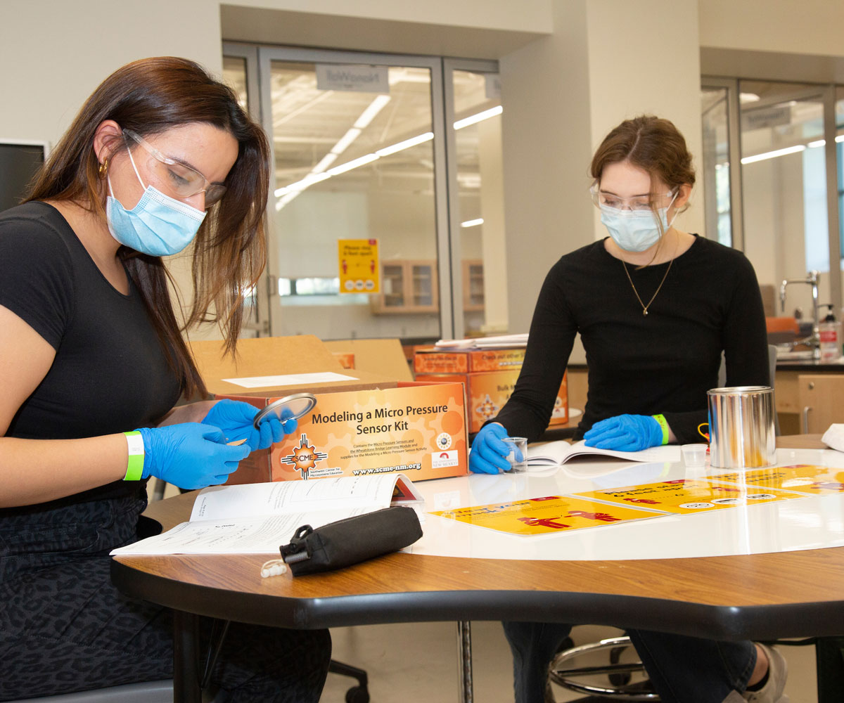 students wear a mask while working in a lab.